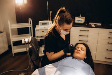 Klinikte estetik cerrah hastanın yüzüne izler sürüyor. Yüksek kalite fotoğraf