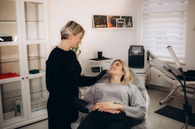 Profesyonel makyaj sanatçısı ve müşterisi dudak kızarma işlemi sırasında. Yüksek kalite fotoğraf