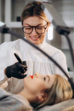 Dudaklarında kalıcı makyaj malzemesi var. Yüksek kalite fotoğraf