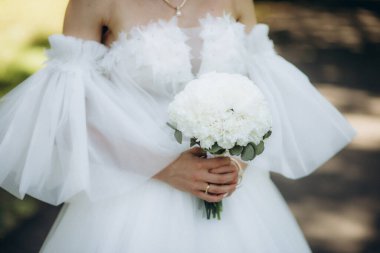 Gelin yumuşak bir düğün buketi tutuyor. Yüksek kalite fotoğraf