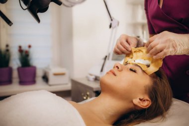 Güzellik uzmanı güzel bir kadının maskesini çıkarıyor. Yüksek kalite fotoğraf