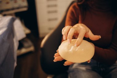 Plastik Kozmetik Cerrahı Geleceğin Ameliyatı için Kadın Göğüs İmplantı Örnekleri Gösteriyor. Saygın Klinikte Çalışan Profesyonel ve Ünlü Cerrah