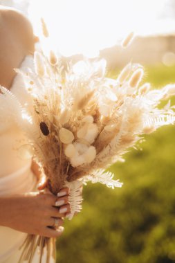 Gelin elinde bir buket çiçek tutuyor. Yüksek kalite fotoğraf. Yüksek kalite fotoğraf