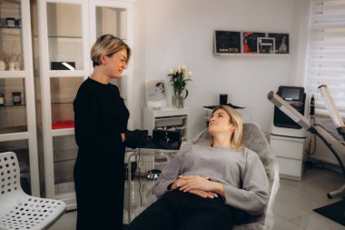 Profesyonel makyaj sanatçısı ve müşterisi dudak kızarma işlemi sırasında. Yüksek kalite fotoğraf