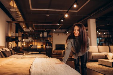 Galeride yeni bir yatak odası mobilyası alırken gülümseyen mutlu kadın. Yüksek kalite fotoğraf