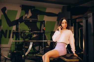 Spor salonunda telefonda konuşan mutlu genç bayan sporcu, fotokopi odası. Yüksek kalite fotoğraf