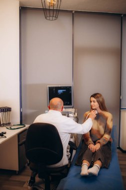 Klinikteki genç bir kadında tiroit bezinin ultrason teşhisi. Yüksek kalite fotoğraf