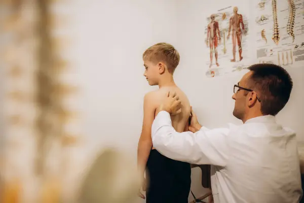 Doktor klinikteki küçük kızın duruşunu kontrol ediyor. Yüksek kalite fotoğraf