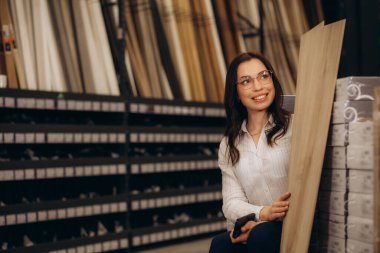 İç dizayn mağazasındaki yeni evi için malzeme seçen genç bir kadın. Yüksek kalite fotoğraf