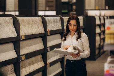 Apartmandaki kadın duvar kağıdı seçiyor. Yüksek kalite fotoğraf. Yüksek kalite fotoğraf