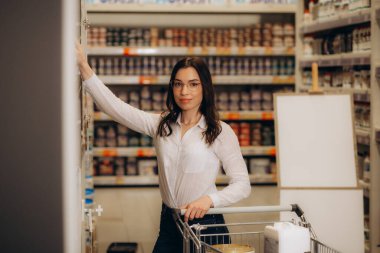 Genç Kadın Hırdavatçı Dükkanındaki Duvarlar İçin Boya Seçiyor. Plastik kovalardaki beton yüzeyler için akrilik boya. Yüksek kalite fotoğraf