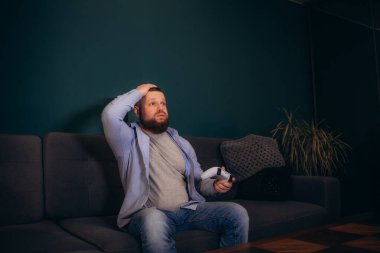 Genç mutlu adam hafta sonları gülüyor ve video oyunları oynuyor. Yüksek kalite fotoğraf