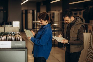 Genç çift seramik fayans seçiyor, hırdavatçı dükkanı. Yüksek kalite fotoğraf