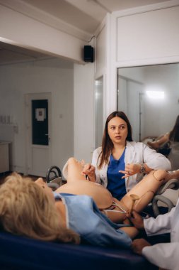 Öğretmen, doğum uzmanı ve jinekolog öğrencileri için pratik bir seans düzenler.
