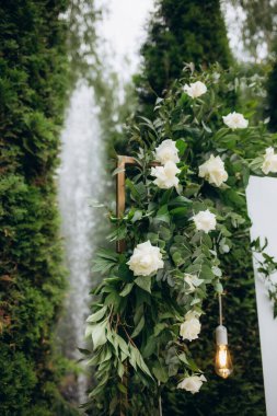Açık hava düğün töreni için taze çiçeklerle süslenmiş bir düğün kemeri. Modaya uygun bir düğün dekoru. Yüksek kalite fotoğraf