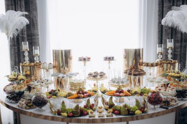 Düğün için açık büfe meyve. Restorandaki üzüm bağlarının arka planında egzotik meyveler var. Taze meyve süslemesi. Yüksek kalite fotoğraf