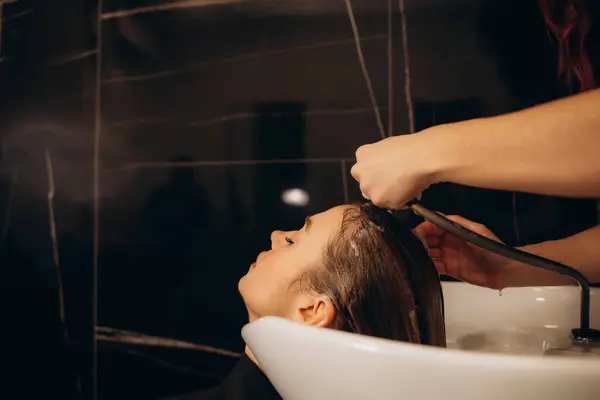 hairdresser washing client\'s hair at salon. happy young women customer relax and comfortable while washing hair, luxury hair spa by professional hairstylist. High quality photo