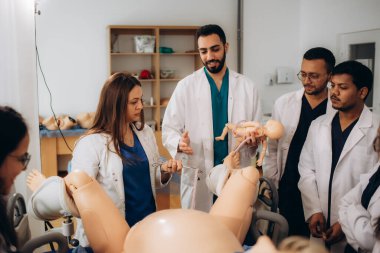 Jinekoloji öğrencilerini özel bir mankenin üzerinde doğum konusunda eğitme süreci.