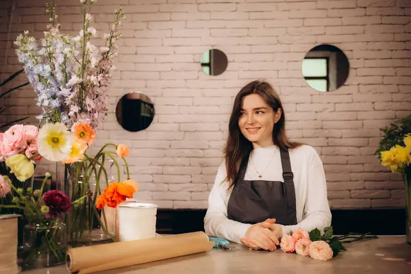 Çiçekçi, çiçekçi dükkanında bir buket güzel renkli çiçek düzenliyor. Yüksek kalite fotoğraf