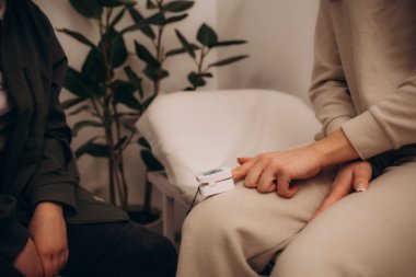 Doktor ve hasta parmak nabız oksimetre kullanarak. Yakın çekim