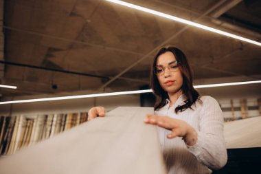 Evini yenilemek için katın kaplamasını seçen genç kadın..