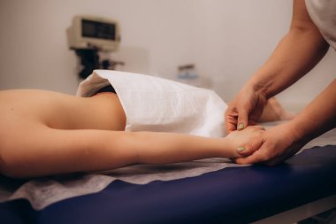 Çocuklar için sağlık masajı. Masörün elleri, yakın plan. Klinikte hastayla çalışan fizyoterapist.