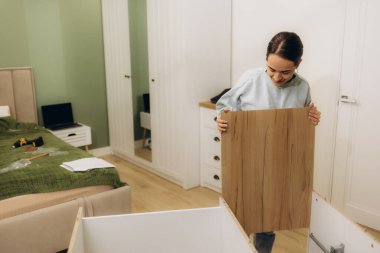 Genç bayan mobilyaları kendi evinde monte ediyor.. 