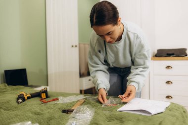 Kadınlar yeni evlerinde mobilya monte etme talimatlarını okuyorlar