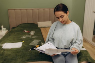 Mobilya montajı için elinde elektrikli tornavida tutan ve kullanma kılavuzu okuyan kadınlar.