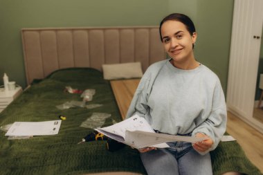 Mobilyaları monte etmek için kullanma kılavuzu okuyan kadın