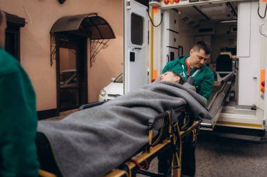 Ambulanstaki ciddi ve profesyonel doktorlar acil bir durum sırasında bir hastayı hastaneye götürüyorlar..