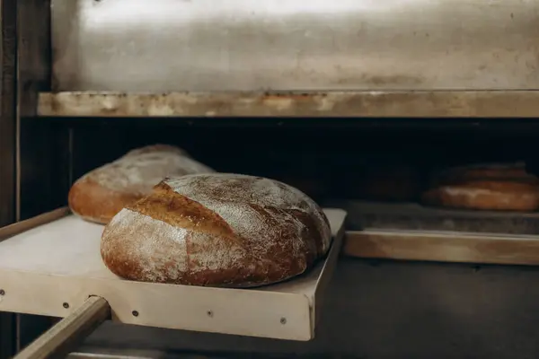 Bäcker Legt Brot Den Backofen Und Kauert Auf Dem Boden Stockfoto