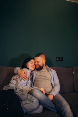 Oturma odasında bir koltukta otururken çift birlikte televizyon izler. Kız arkadaş ve erkek arkadaş kucaklaşır, sarılır, konuşur, gülümser ve TV Akımı Hizmetleri 'ni izler. Konforlu İç Modaya sahip Ev.