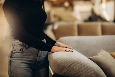 Bir kadın bir mağazadaki kanepenin tekstilini elleriyle deniyor.