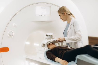 Radyolog, bilgisayarlı tomografi odasında bir kadın hasta ile birlikte.
