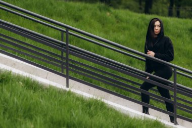 Fitness, spor ve sağlıklı yaşam tarzı konsepti. Mutlu gülümseyen Afro-Amerikan kadını açık havada koşuyor.