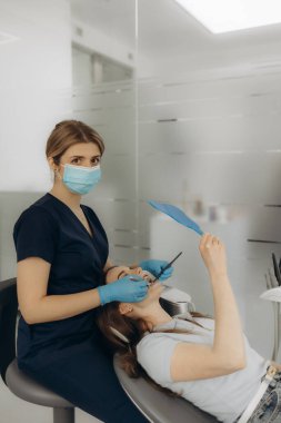 Doktor hastanın dişlerini muayene ediyor, yakın plan. Kozmetik dişçiliği