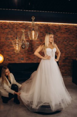 Gelinliği galeride seçen kadın. Müstakbel gelin dükkandan gelinlik alıyor..