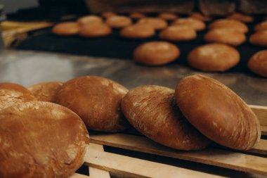 Tahta zeminde taze ekmek ve buğday kulakları.