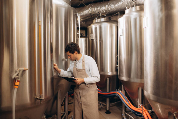 Concentrated man using ladder in brewery