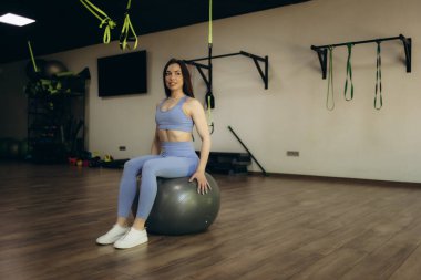 Formda kız antrenmanı, spor salonunda kalas pozisyonunda..