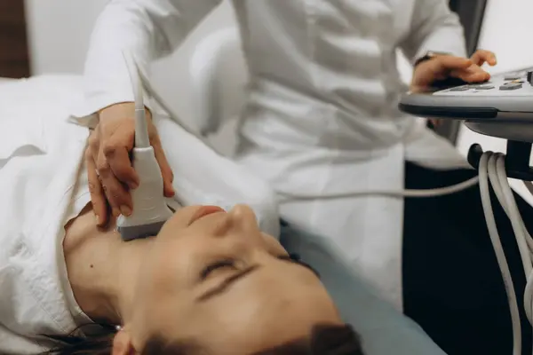 stock image panoramic shot of doctor examining thyroid of female patient with ultrasound scan in clinic