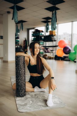 Kadın eğitimi, genç bir kadın antrenmandan önce ya da sonra ısınıyor ve esniyor.