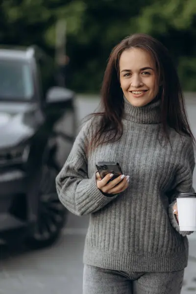 Stock image Woman charging her electric car with charging pistol