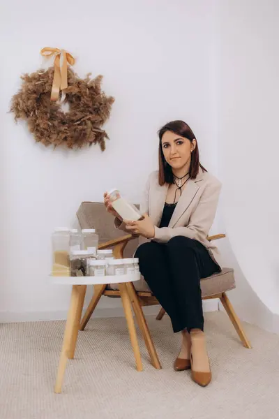 Stock image A woman in a suit puts cereals in jars