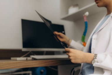 Genç tıp uzmanı, akciğer röntgeni görüntülerini inceliyor.