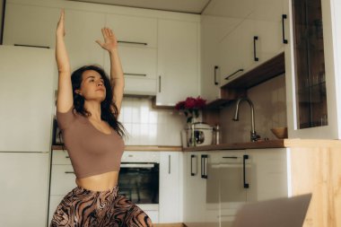 Mutfakta bir kadın geriliyor.