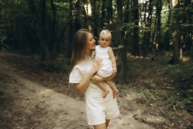 Ormanda bebeğiyle yürüyen bir anne.