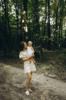 Ormanda bebeğiyle yürüyen bir anne.