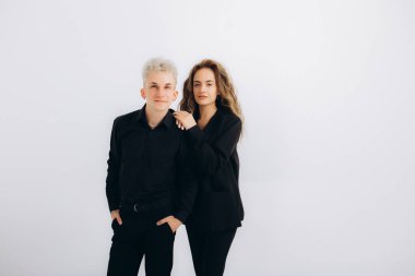 Beyaz arka planda siyah takım elbiseli dans eden bir çift.